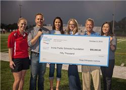 Group of 6 people holding $50,000 check